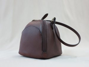ダークブラウン色の細かな型押しがされた牛革で作ったころりとしたハンドバッグ