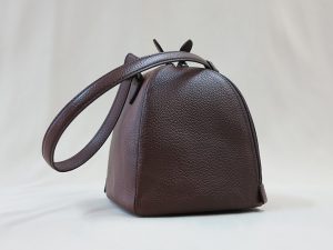ダークブラウン色の細かな型押しがされた牛革で作ったころりとしたハンドバッグ